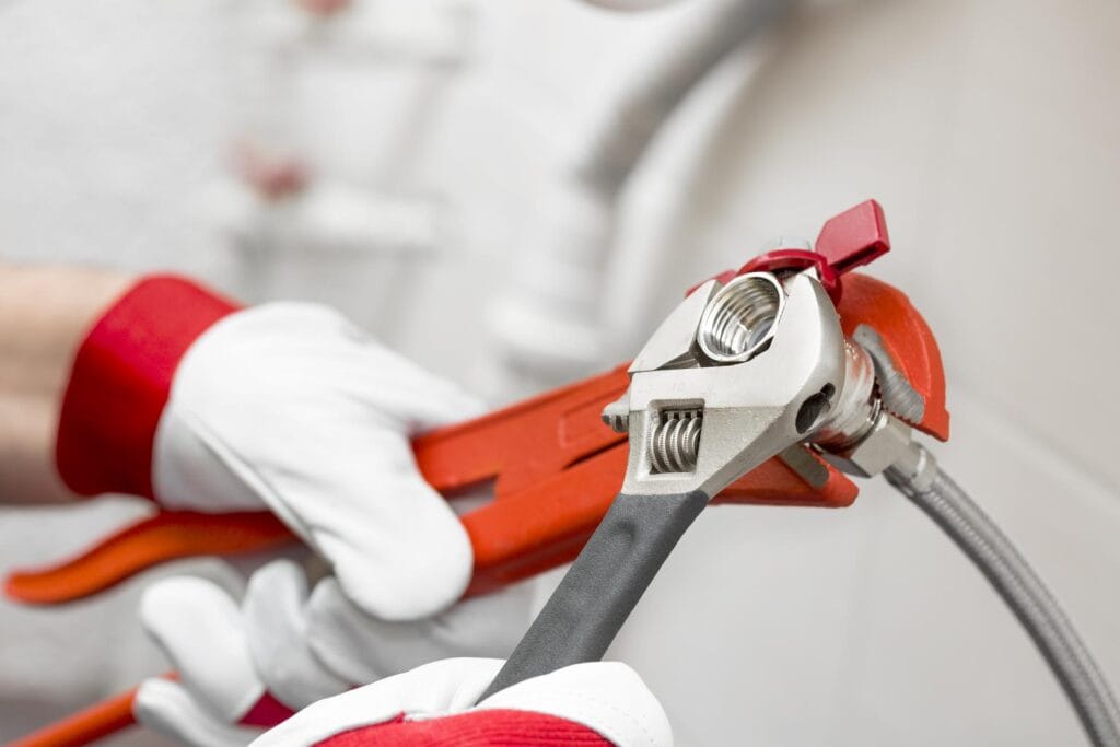 Plumber holding pipe wrenches for an emergency repair in Maitland