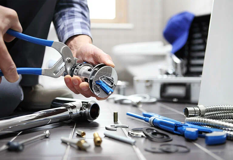 Technician repairing a plumbing fixture with professional tools in Maitland