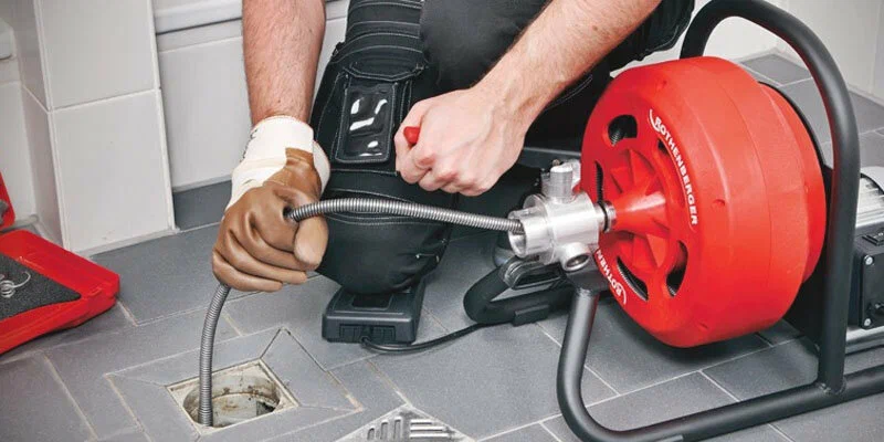 Plumber using a drain-cleaning machine in Maitland