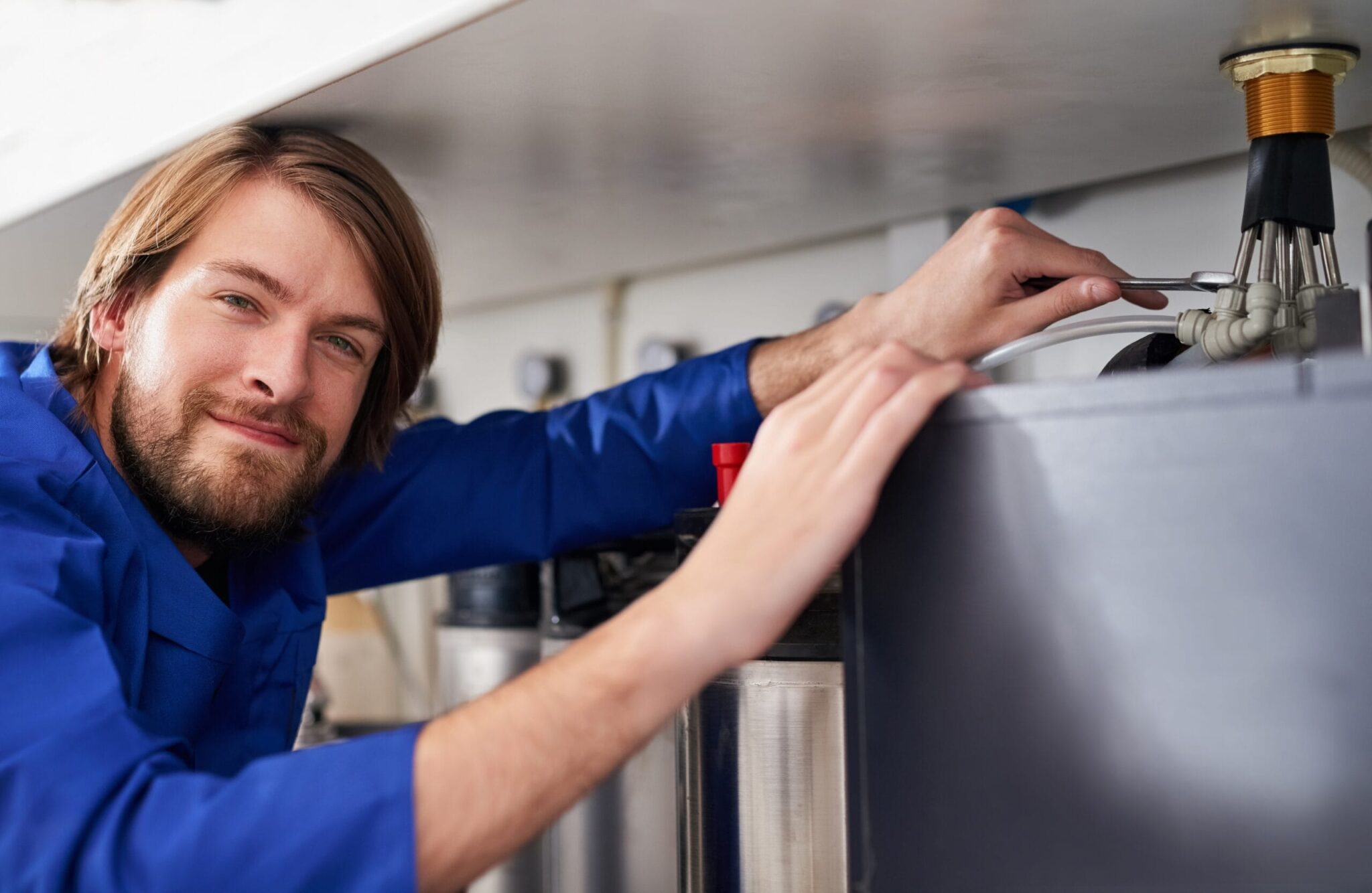 Technician servicing a residential water heater tank in Maitland