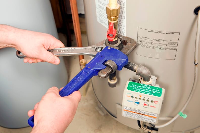 Plumber repairing a water heater valve in Maitland